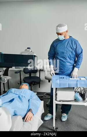 Ein Arzt in Peelings steht aufmerksam neben dem Patientenbett. Stockfoto