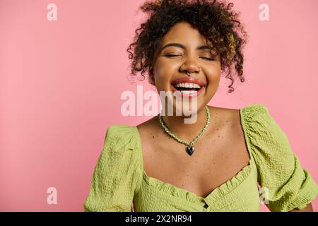 Eine schöne afroamerikanische Frau posiert in einem stilvollen gelben Kleid und lächelt strahlend. Stockfoto