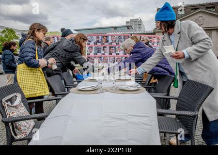 Berlin, Deutschland. April 2024. Am 23. April 2024 markierte eine Versammlung auf dem Wittenbergplatz einen ergreifenden Akt des Gedenkens und der Solidarität für die Geiseln, die die Hamas nach dem Angriff auf Israel am 7. Oktober 2023 noch immer festgehalten hat. Auf dem Tisch in Berlin standen symbolische Pessach-Gegenstände, darunter der Seder-Teller und Weintassen, die unberührt blieben. Jeder Stuhl repräsentierte eine der Geiseln und spiegelte die leeren Räume im Leben ihrer Familien wider. (Foto: Michael Kuenne/PRESSCOV/SIPA USA) Credit: SIPA USA/Alamy Live News Stockfoto