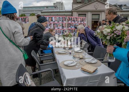 Berlin, Deutschland. April 2024. Am 23. April 2024 markierte eine Versammlung auf dem Wittenbergplatz einen ergreifenden Akt des Gedenkens und der Solidarität für die Geiseln, die die Hamas nach dem Angriff auf Israel am 7. Oktober 2023 noch immer festgehalten hat. Auf dem Tisch in Berlin standen symbolische Pessach-Gegenstände, darunter der Seder-Teller und Weintassen, die unberührt blieben. Jeder Stuhl repräsentierte eine der Geiseln und spiegelte die leeren Räume im Leben ihrer Familien wider. (Foto: Michael Kuenne/PRESSCOV/SIPA USA) Credit: SIPA USA/Alamy Live News Stockfoto