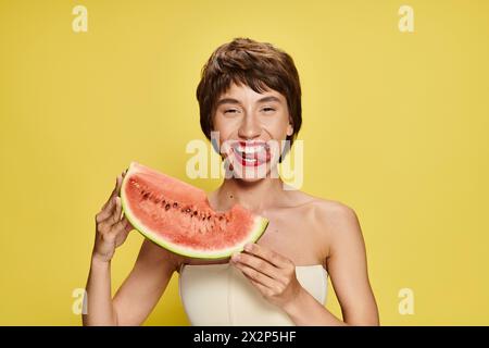 Eine Frau hält ein Stück Wassermelone vor ihr Gesicht. Stockfoto