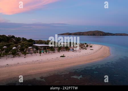 Labuan Bajo, Indonesien: Dramatischer Sonnenuntergang über Bungalows an einem idyllischen Strand auf einer kleinen Insel in der Nähe von Komodo in Flores in Indonesien Stockfoto