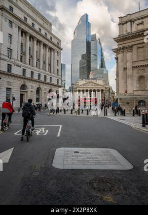 London, Großbritannien: City of London in der Nähe der Bank Station. Blick auf die Royal Exchange mit Wolkenkratzern im Hintergrund und Radfahrern im Vordergrund. Stockfoto