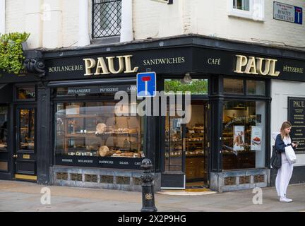 Paul Patisserie und Boulangerie Ecke Kings Road und Bywater Street. Die junge Frau steht draußen mit dem Handy. Chelsea, London, England, Großbritannien Stockfoto