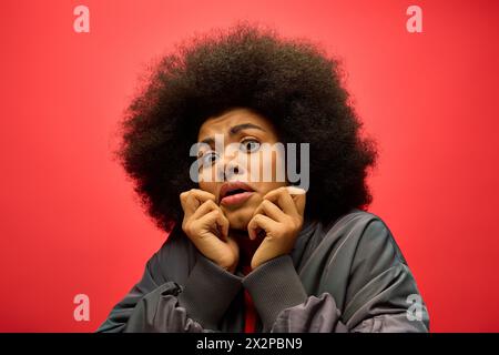 Stilvolle afroamerikanische Frau in trendiger Kleidung mit überraschtem Ausdruck. Stockfoto