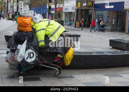 Slough, Berkshire, Großbritannien. April 2024. Der tragische Anblick eines Obdachlosen aus Osteuropa, mit all seinen weltlichen Besitztümern, die in Plastiktüten von einem Einkaufswagen in der Slough High Street hängen. Das neue Gesetz über Strafrechtspflege wird derzeit vom Parlament durchlaufen und würde es der Polizei ermöglichen, „belästigende“ Schläfer mit Geldbußen zu belegen. Das Gesetz würde bedeuten, dass raue Schläfer weitergezogen werden könnten, mit einer Geldstrafe von bis zu 2.500 Pfund belegt oder inhaftiert werden könnten. Quelle: Maureen McLean/Alamy Live News Stockfoto