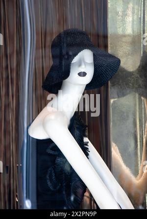 Belgrad, Serbien - 3. April 2024: Puppe mit schwarzem gehäkeltem Sonnenhut mit Reflexionen im Schaufenster des Max Mara-Geschäfts Stockfoto