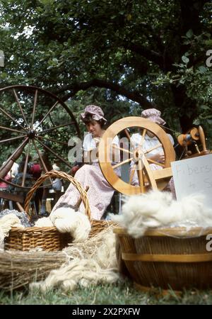 Connecticut, USA, 1982. Frau, die ein drehendes Rad benutzt; historische Nachstellung auf einer Kulturmesse. Stockfoto