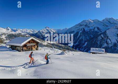 Reifes Paar zurück Langlaufen in der Nähe von Hütte am schneebedeckten Rastkogel am sonnigen Tag, Zillertaler Alpen, Tuxer Alpen, Tirol, Österreich Stockfoto