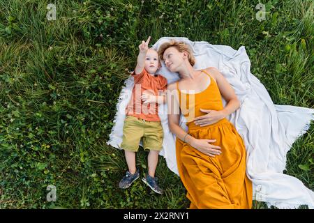 Mutter und Sohn liegen auf einer Decke über Gras auf der Wiese Stockfoto