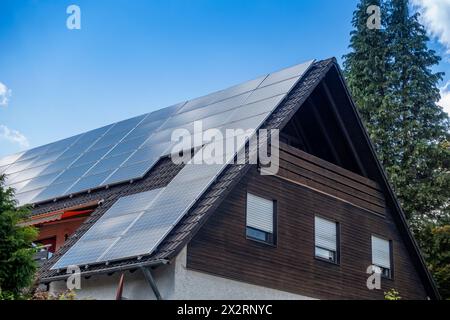 Solarpaneele auf dem Dach des Hauses unter blauem Himmel in Bayern, Deutschland Stockfoto