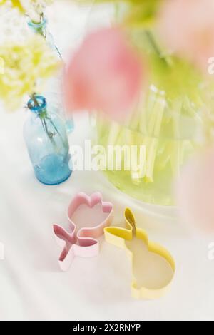 Bunte Keksschneider und Blumen auf dem Tisch Stockfoto