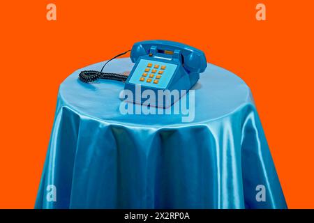 Telefon im Vintage-Stil auf dem Tisch mit orangefarbenem Hintergrund Stockfoto