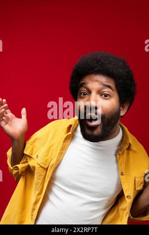 Junger Mann mit gelbem Hemd auf rotem Hintergrund Stockfoto