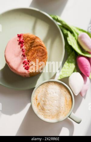 Eine Tasse Kaffeepause mit rosafarbener Schokolade und gefriergetrockneten Himbeeren auf dem Tisch Stockfoto