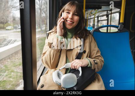 Lächelnder Passagier, der auf dem Handy im Bus spricht Stockfoto