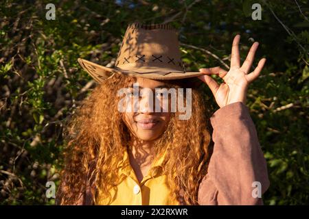 Eine junge Frau mit lockigem Haar und Cowboyhut Stockfoto