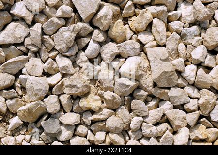 Straßenoberfläche für Hintergrund. Weißer zerdrückter Stein. Draufsicht auf Schotterstraßenfragment. Trockenes Land mit Steinen. Steine und Kiesel auf dem Boden. Stockfoto