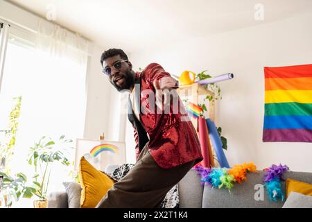 Modische nicht-binäre Person, die zu Hause im Wohnzimmer tanzt Stockfoto