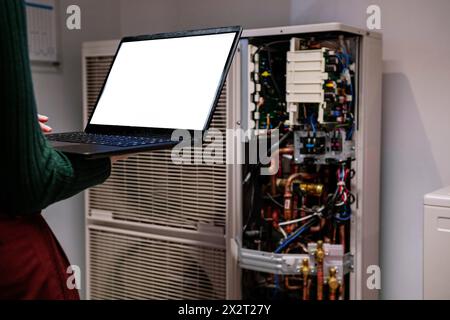 Ingenieur hält Laptop und steht in der Nähe des Netzwerkservers im Büro Stockfoto