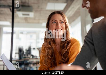 Glückliche, reife Geschäftsfrau mit Kollege im Amt Stockfoto