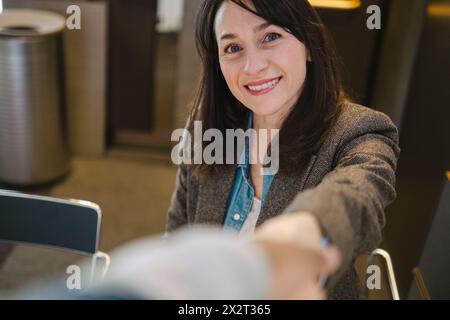 Lächelnde, reife Geschäftsfrau in braunem Blazer Stockfoto