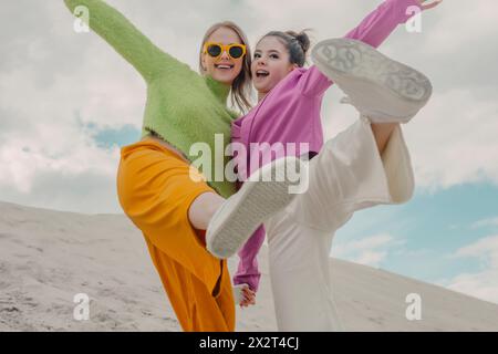 Fröhliche Frauen, die sich auf der Sanddüne amüsieren Stockfoto