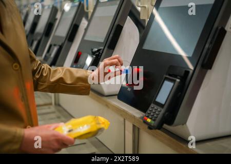 Junge Frau mit Infrarot-Selbstkiosk-Service Stockfoto