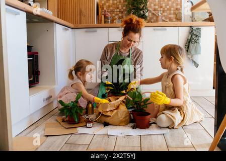 Töchter helfen Mutter beim Pflanzen von Pflanzen zu Hause Stockfoto