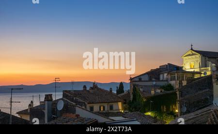 Italien, Latium, Anguillara Sabazia, Dächer von Häusern mit Blick auf den See Bracciano in der Abenddämmerung Stockfoto