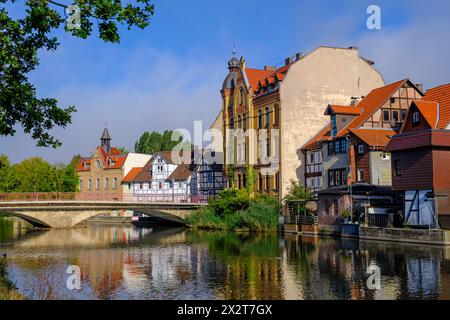 Deutschland, Hessen, Eschwege, historische Häuser entlang der Werra mit Bogenbrücke im Hintergrund Stockfoto