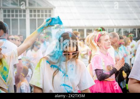 Die junge Frau hat beim Colour Run farbiges Pulver über den Kopf gegossen, zu Hilfe von St. Rocco's Hospice, Warrington Stockfoto