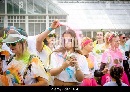 Die junge Frau hat beim Colour Run farbiges Pulver über den Kopf gegossen, zu Hilfe von St. Rocco's Hospice, Warrington Stockfoto