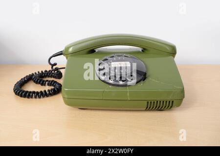 Altes grünes Drehtelefon mit Disc Dial, altes Telefon mit Rissen, Verbindung mit Vergangenheit, veraltete Technologie, Kommunikation aus den 80er Jahren Stockfoto