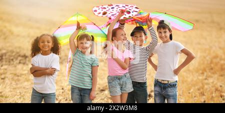 Kleine Kinder fliegen Drachen auf dem Feld Stockfoto