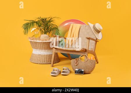 Sessel mit Strandaccessoires und ein Glas Cocktail auf dem Tisch vor farbigem Hintergrund Stockfoto