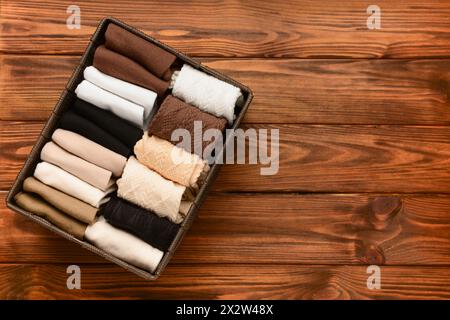 Organizer mit Socken in Grundfarbe auf Holzhintergrund Stockfoto
