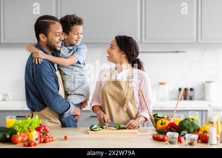 Glückliche Familie, die zusammen in der Küche kocht Stockfoto