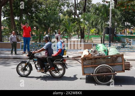 Maracay, Venezuela. April 2024. Der 2,34 Meter hohe venezolanische Jeison Rodriguez (2. Von links) winkt den Nachbarn zu. Rodriguez erhielt von dem deutschen Schuhmacher Wessels eigens für seine Füße hergestellte Schuhe, die mehr als 40 Zentimeter lang sind. Quelle: Jesus Vargas/dpa/Alamy Live News Stockfoto