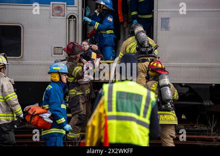 Bei einer Massenbohrung, die am 21. April 2024 in Amagansett, NY, durchgeführt wurde, werden die Opfer von einem LIRR-Zug (Long Island Rail Road) entfernt. Die Übung wurde von der Amagansett Fire Department in Zusammenarbeit mit der East Hampton Town Chiefs Association, dem Stony Brook Southampton Hospital und dem MTA/LIRR organisiert. Stockfoto