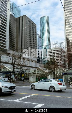 Ein Foto der Skytrain Burrard Station mit Autos im Vordergrund und dem Paradox Hotel Turm und anderen hohen Gebäuden im Hintergrund Stockfoto