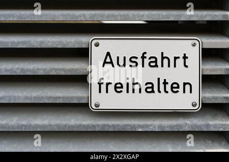 Schild am Tor eines Parkhauses mit der deutschen Aufschrift "Ausfahrt freihalten". Übersetzung: Beenden leer lassen Stockfoto