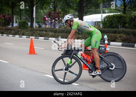 13. April 2024. T100-Triathlon-Event mit weiblicher Athletik auf ihrem sportlichen Rennrad, das eine Kehrtwende um den Kegel macht. Singapur. Stockfoto