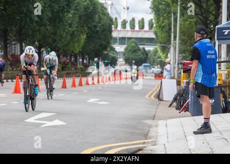 13. April 2024. T100-Triathlon-Chefschiedsrichter, die die Leichtathletikerin auf der Straße über eine 80 km lange Distanz ansieht. Singapur Stockfoto