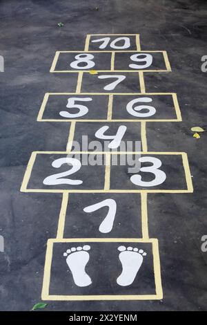 Hopscotch lackierte, unauslöschbare Tinte auf schwarzem Asphalt für Kinder im Freien. Stockfoto