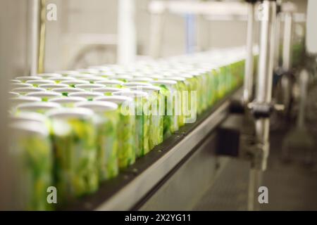 Leere Aluminiumdosen für Getränke werden auf einem Förderband in einer großen Fabrik transportiert. Geringe Schärfentiefe. Stockfoto