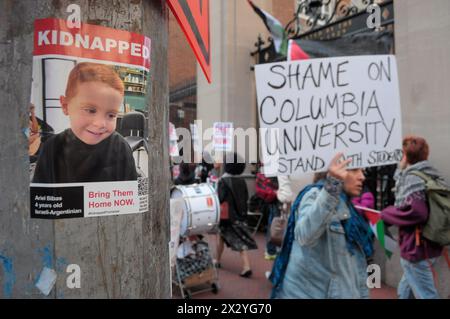 Ein Poster mit einem Foto eines von der Hamas entführten Kindes wird gesehen, als palästinensische Demonstranten während einer Kundgebung an der Columbia University Plakate halten, auf denen ihre Meinung zum Ausdruck gebracht wird. Pro-palästinensische Demonstranten versammelten sich an einem der Eingänge der Columbia University in Manhattan, New York City, um die Militäroperationen der israelischen Streitkräfte in Gaza zu verurteilen. Seit vergangener Woche haben Studenten und pro-palästinensische Aktivisten innerhalb der Universität einen Sit-in-Protest auf dem Rasen abgehalten und ein "Gaza Solidarity Encamp" gebildet. Studierende an anderen Universitäten haben ähnliche Campings in den Universitäten landesweit in en gebildet Stockfoto