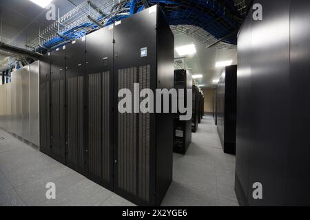 Serverraum mit den Telekommunikations-Racks und vielen blauen und schwarzen Kabeln. Stockfoto