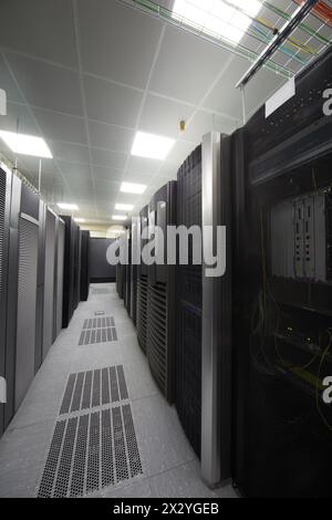 Telekommunikationsgeräte in Racks und farbige Kabel im Serverraum. Stockfoto