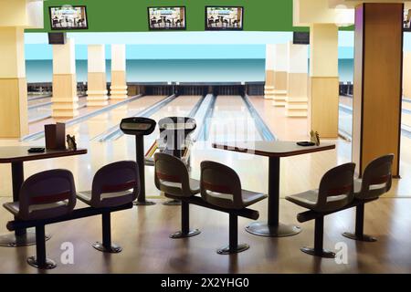 Kleine leichte Bowlingbahn mit hängenden Displays, Tisch und Stühlen. Stockfoto